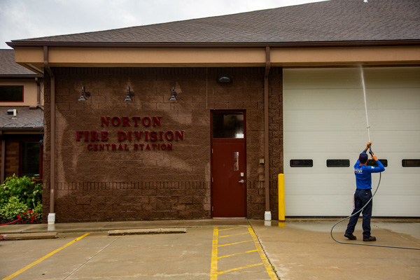 Member of Hydro Savage Pressure Washing's Dream Team washing the exterior of the fire station in Norton, OH