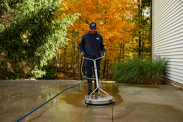 Hydro Savage Pressure Washing employee surface cleaning a driveway