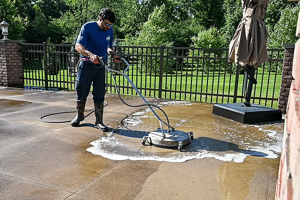 Hydro Savage Pressure Washing technician surface cleaning a concrete patio