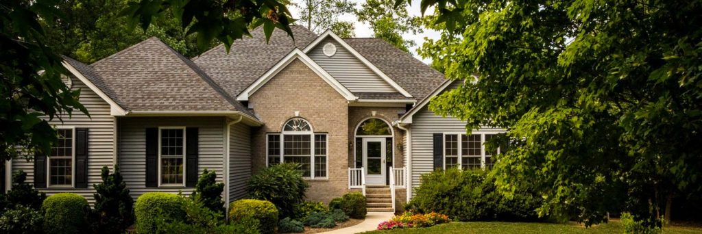 Picture of a brick and vinyl-sided home displaying the many common parts of a house exterior.