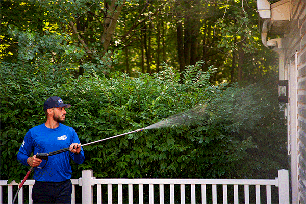 Hydro Savage Pressure Washing employee cleaning siding