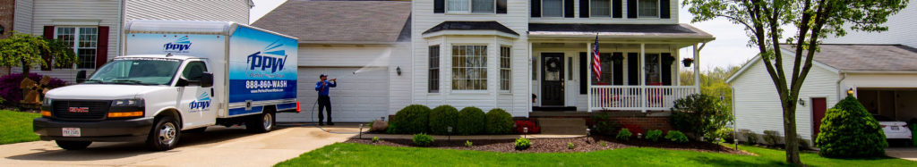 Power washing technician washing vinyl siding. Washing your siding is recommended when you move into a new house.