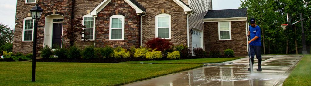 The most common types of concrete sealer are penetrating and topcoat sealers. Here, a power washing technician is applying a penetrating siloxane-silane sealer to a concrete driveway.