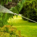 Power washing technician using a wand to safely wash the side of a home